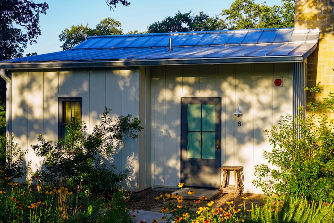 Maison en bois blanc avec plantes vertes illustrant les aides énergétiques 2026